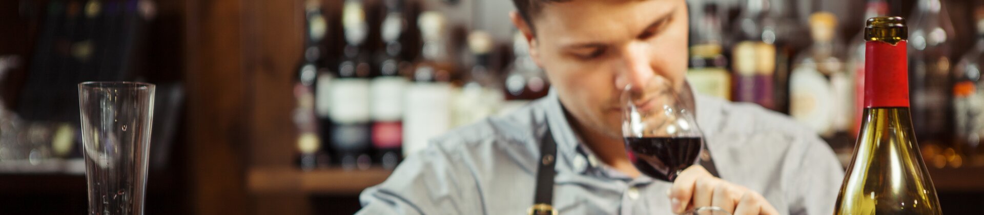 Sommelier degustiert Rotwein und macht professionelle Verkostungsnotizen an der Bar