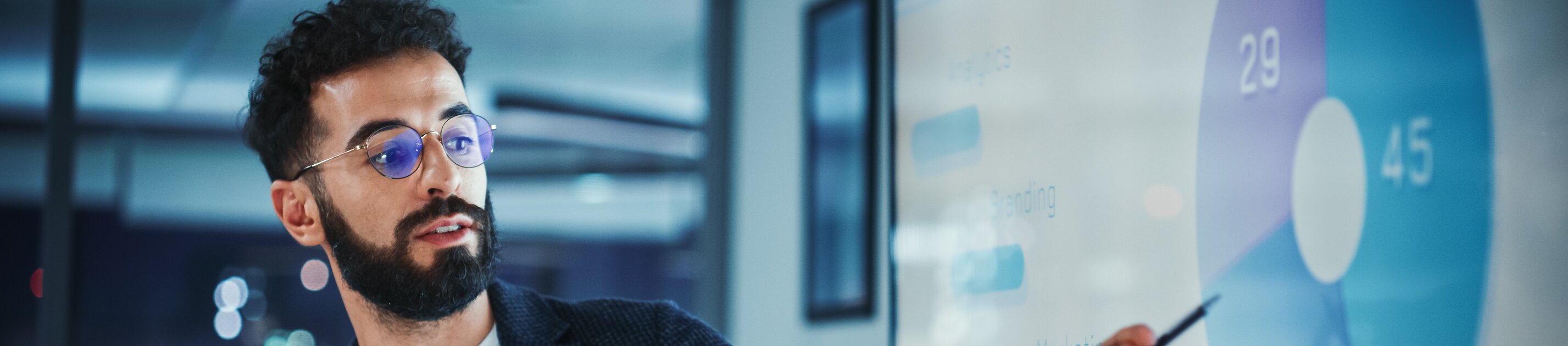 Mann präsentiert Geschäftsdiagramm auf großem Bildschirm während einer professionellen Präsentation