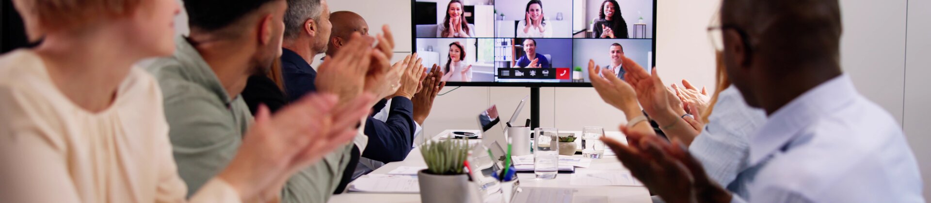 Weiterbildung Hybride Führung: Team nimmt an einer Videokonferenz mit remote zugeschalteten Mitarbeitenden teil.