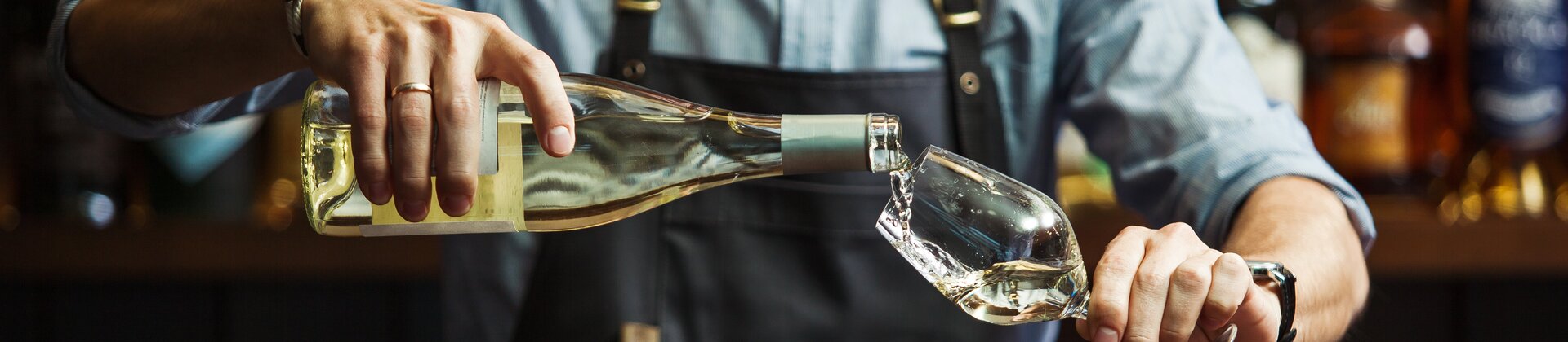 Weiterbildung Gepr. Berufsspezialist/-in Sommelier/-ière: Sommelier schenkt Wein in ein Glas ein.