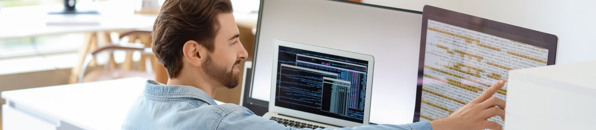 Bachelor Professional in IT Weiterbildung: Mitarbeiter analysiert IT-Systeme und Netzwerke an mehreren Bildschirmen.