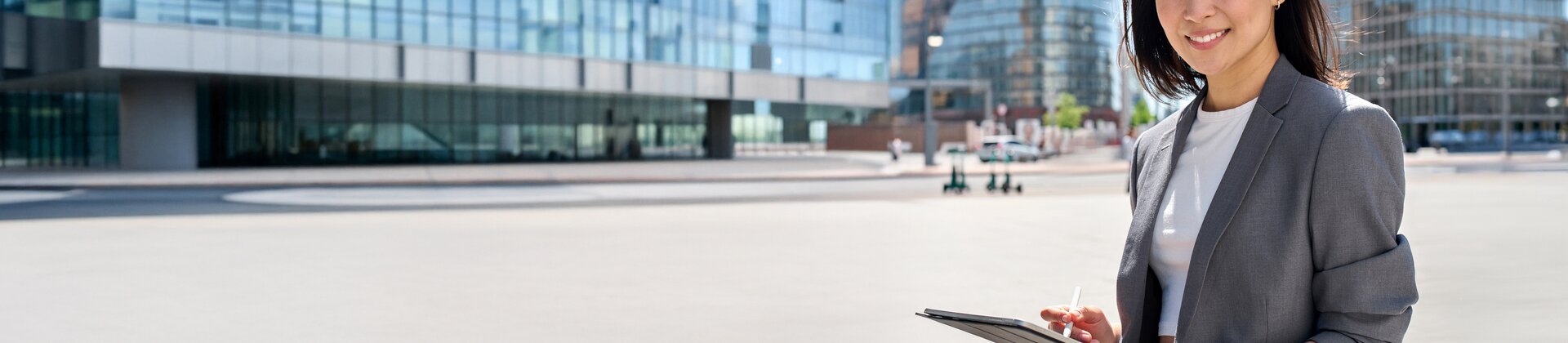 Bachelor Professional in Straßenbetriebsmanagement Weiterbildung: Fachkraft nutzt ein Tablet vor moderner Stadt- und Verkehrsinfrastruktur.