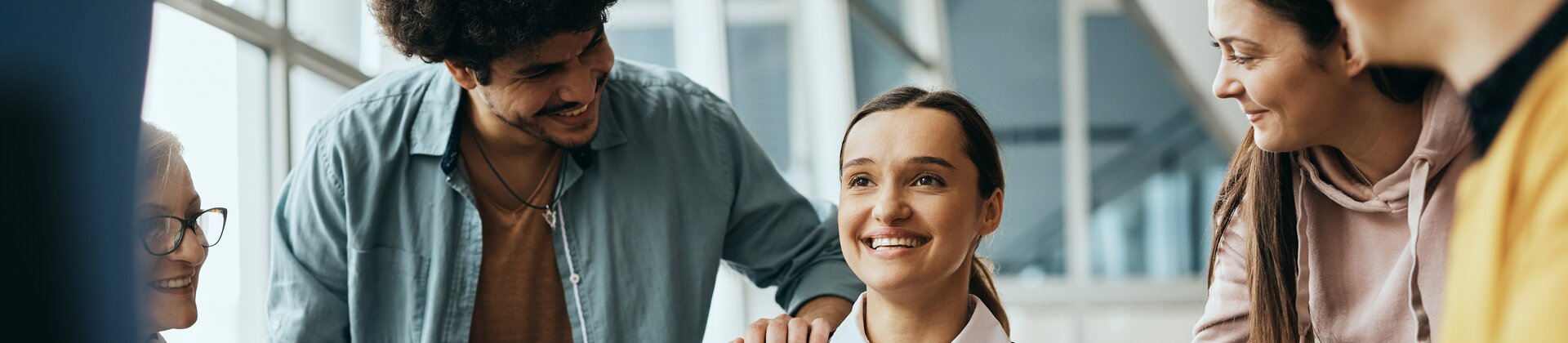 Gruppe von Mitarbeitenden sitzen zusammen und sprechen über mentale Gesundheit im Unternehmen.