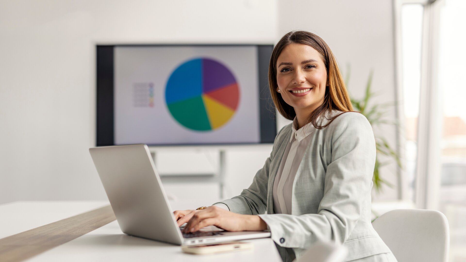 Weiterbildung Online Marketing Manager IHK: Teilnehmerin arbeitet am Laptop mit digitalen Marketingkennzahlen und Diagrammen.