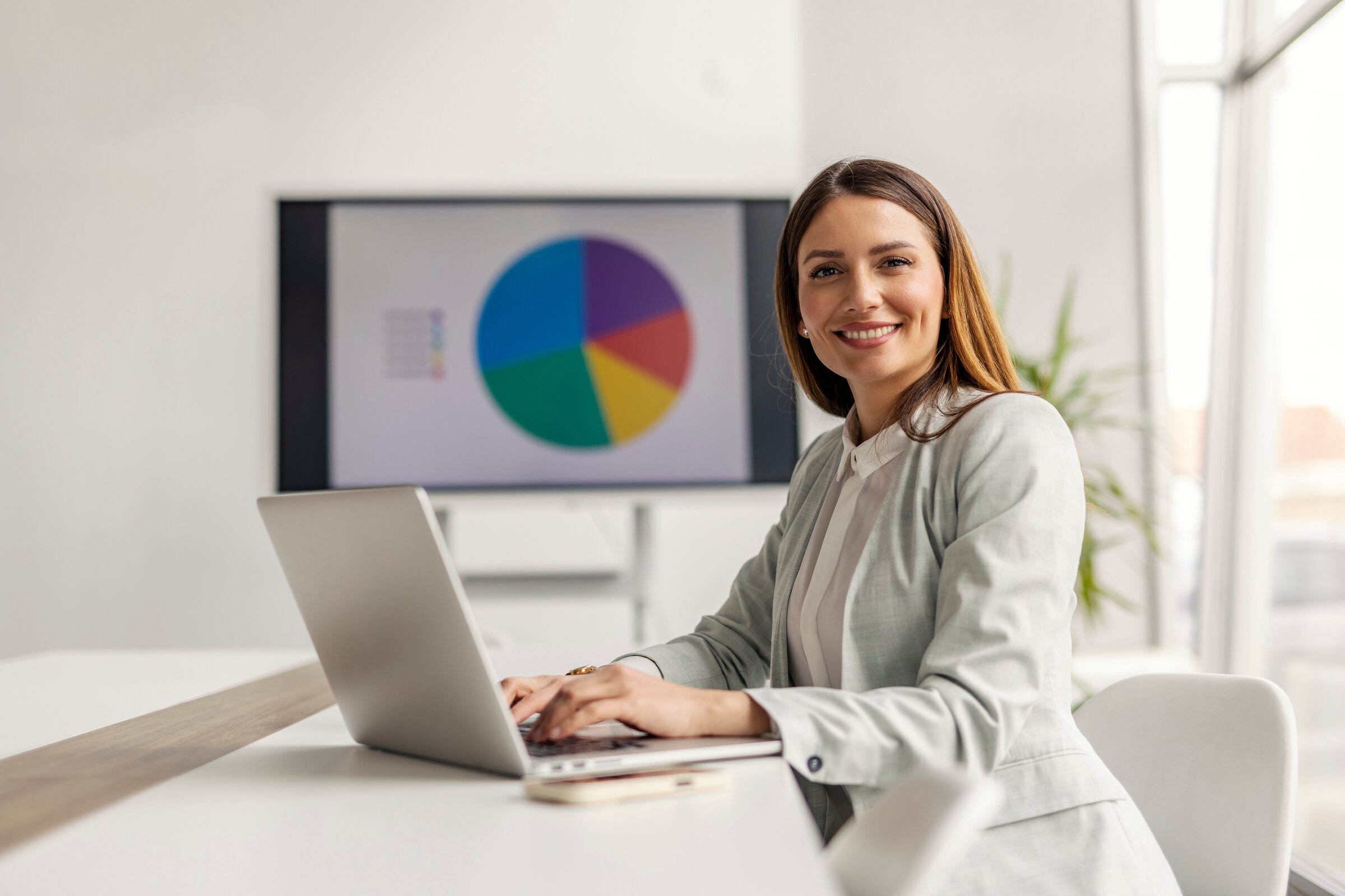 Weiterbildung Online Marketing Manager IHK: Teilnehmerin arbeitet am Laptop mit digitalen Marketingkennzahlen und Diagrammen.