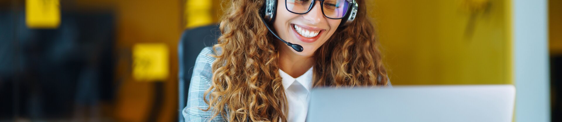 Weiterbildung Knigge und Telefontraining für Azubis: Auszubildende führt ein professionelles Telefonat am Laptop.