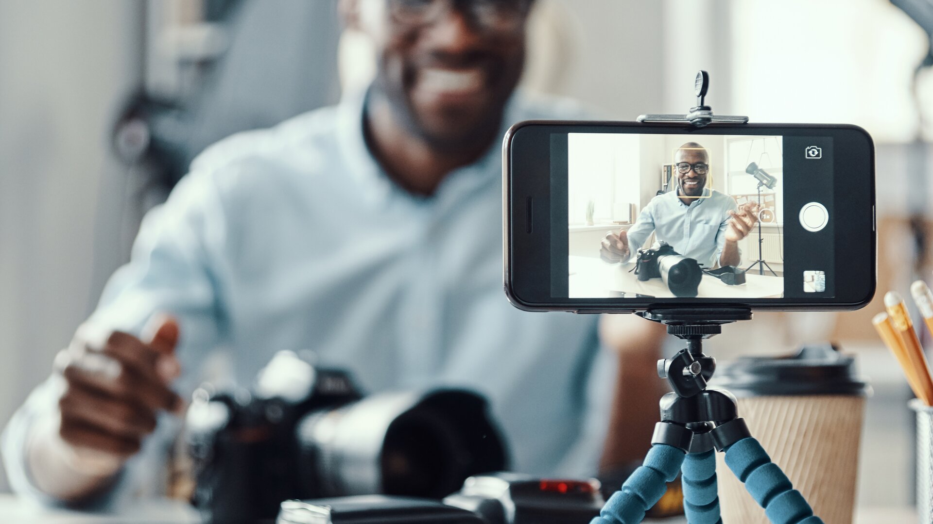 Weiterbildung Video Content Manager IHK: Person erstellt Video-Content mit Smartphone und Kameraequipment.