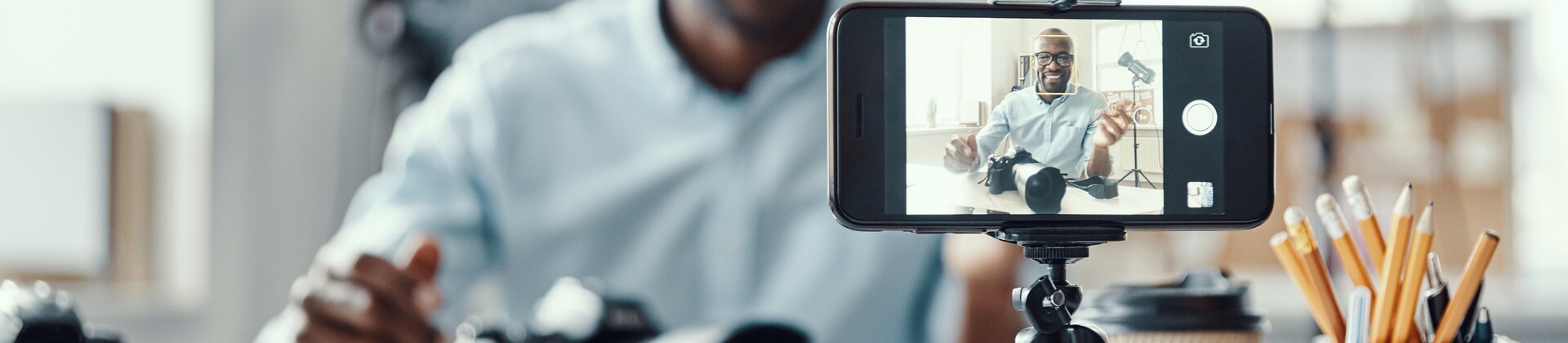 Weiterbildung Video Content Manager IHK: Person erstellt Video-Content mit Smartphone und Kameraequipment.