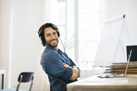 Mann mit Headset im Homeoffice als Symbol für flexible Online-Weiterbildung
