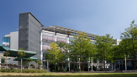 Außenansicht der IHK Akademie München in der Orleansstraße mit modernem Gebäude und begrüntem Vorplatz