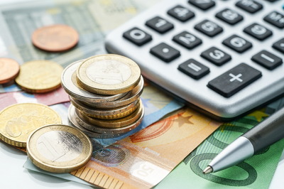 Münzen, Geldscheine und Taschenrechner – Sinnbild für Förderung durch die Agentur für Arbeit mit Bildungsgutschein