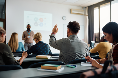 Trainer hält Vortrag vor Teilnehmenden, die sich aktiv am Seminar über Lerntypen beteiligen.