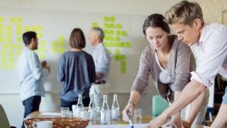 Business people discussing over blueprint at conference table