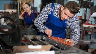 Man is working with level on his workplace in workshop