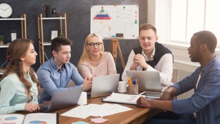 Business corporate meeting of multiethnic team. Young happy successful people brainstorming, discussing new startup project in office, copy space