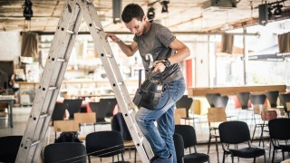 Behind the scene Lighting technician electric engineer adjusting stage lights. Spotlights in the theater