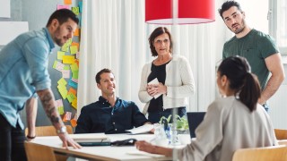 Team of business people discussing project at table in office