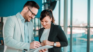 Confident business partners talking in an office building.