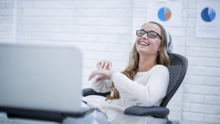 Young woman working in office, laughing