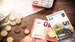 Euro banknotes and coins with bills to pay. Finances and budget concept